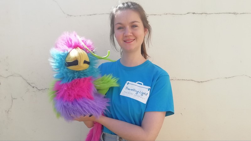 young female wearing blue t-shirt holding a bird puppet