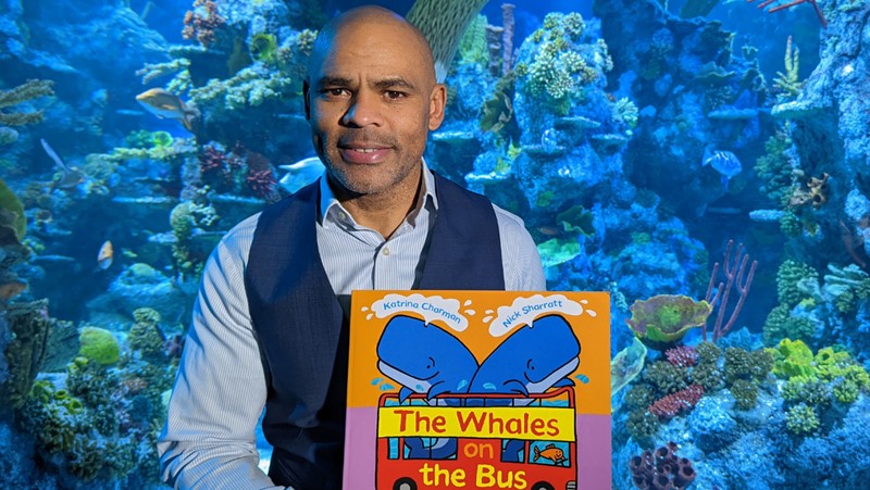 Mayor of Bristol Marvin holding children's book with aquarium fish in background