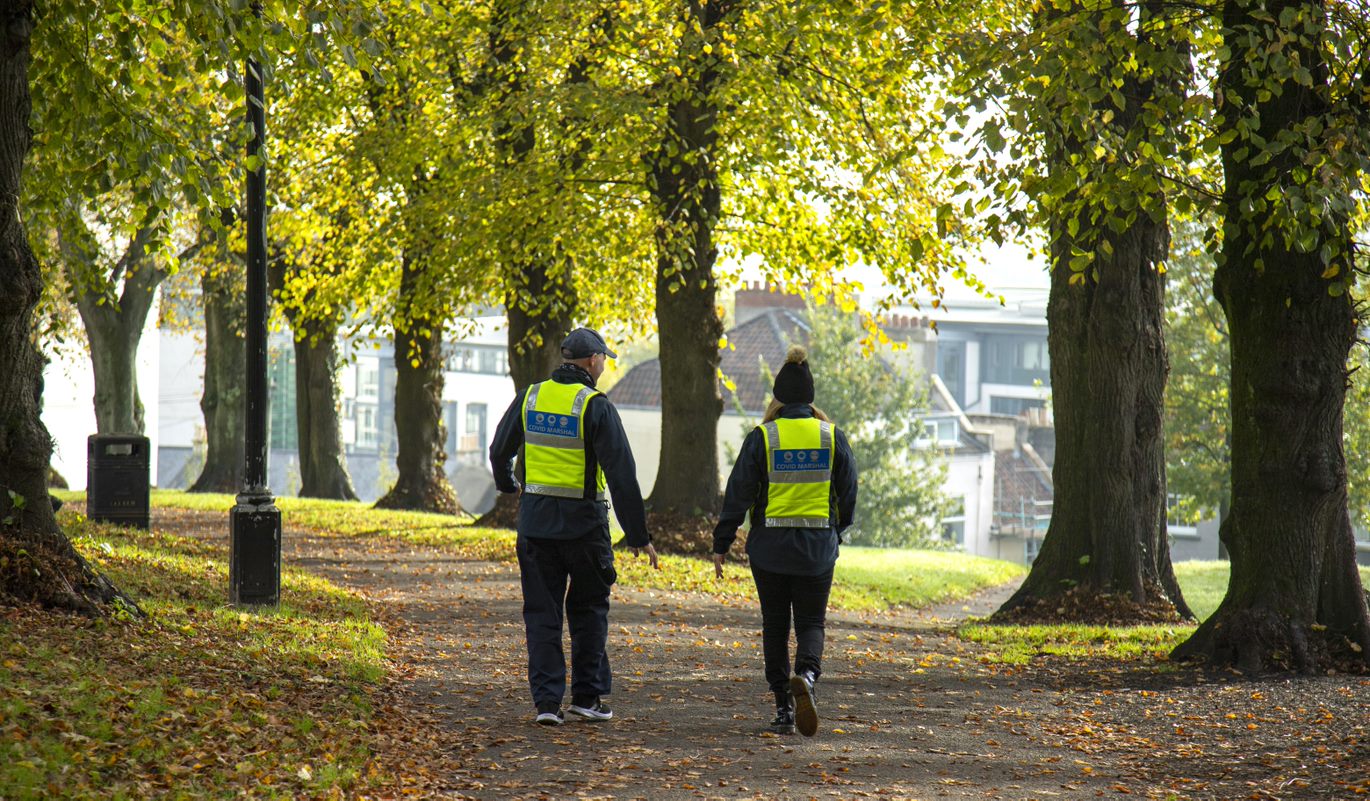 Photo of two Covid Marshalls walking through a park
